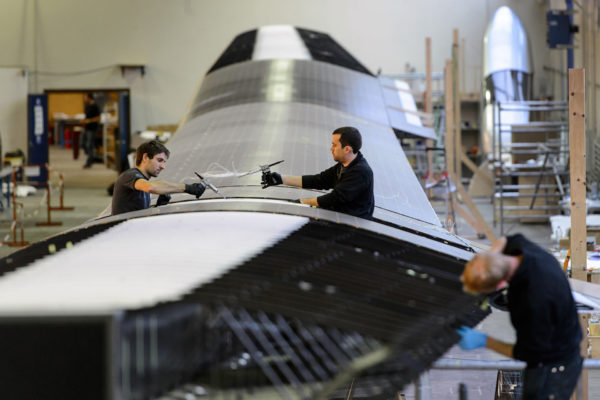Engineers work on the carbon-fibre 72 metres long wing of Swiss sun-powered aircraft Solar Impulse HB-SIB in construction on December 17, 2013 at the former military airport of Duebendorf, near Zurich. After this years flight across the United States with Solar Impulse HB-SIA prototype aircraft, a new larger plane is being built and expected to fly around the world in 2015. AFP PHOTO / FABRICE COFFRINI (Photo credit should read FABRICE COFFRINI/AFP/Getty Images)